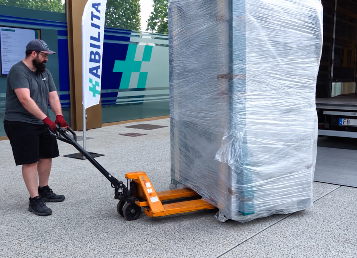 Tecnico movimenta con transpallet un macchinario di grandi dimensioni